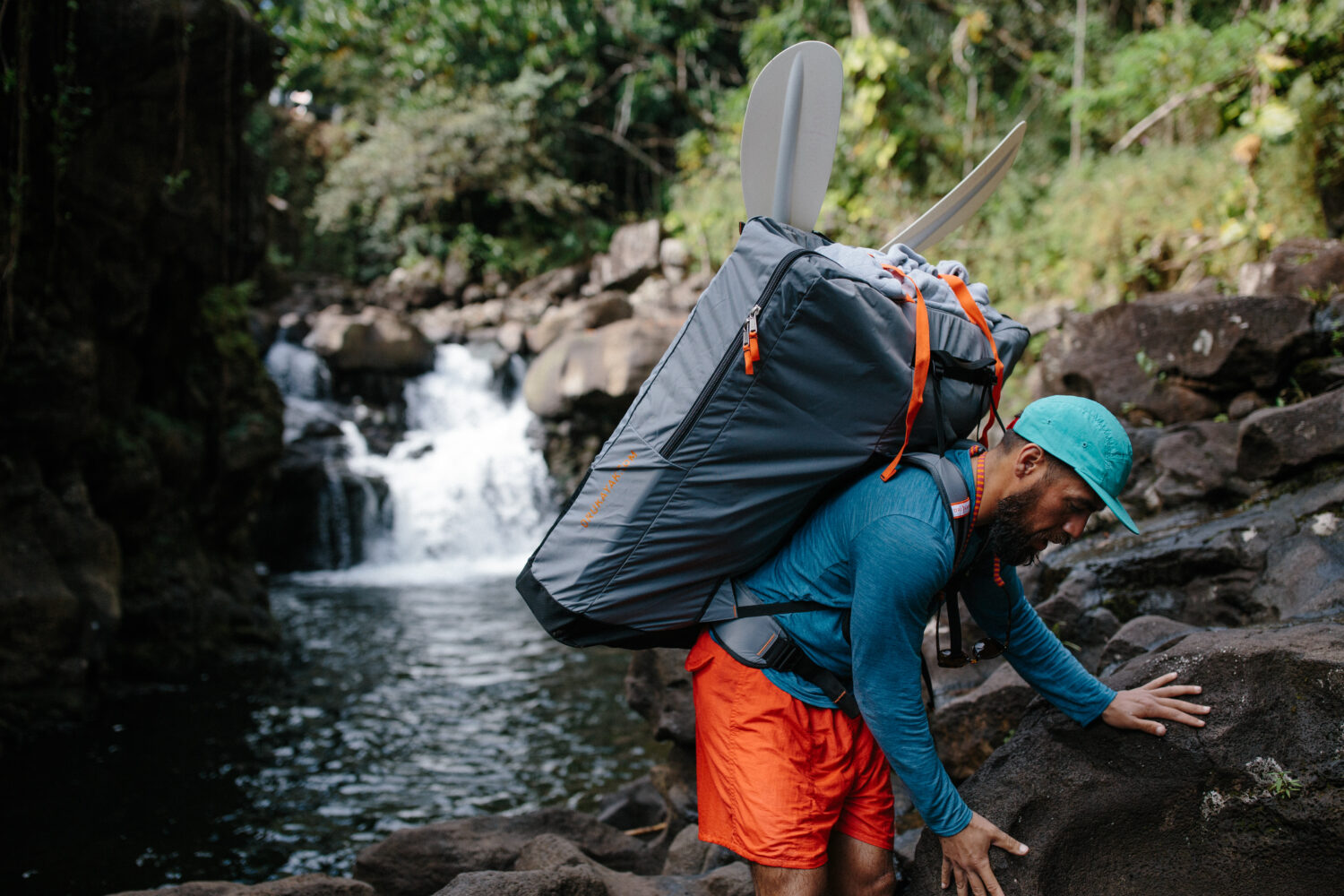 Bild zeigt Mann, der ein Oru Kayak in einem Rucksack inkl. Paddel auf dem Rücken trägt